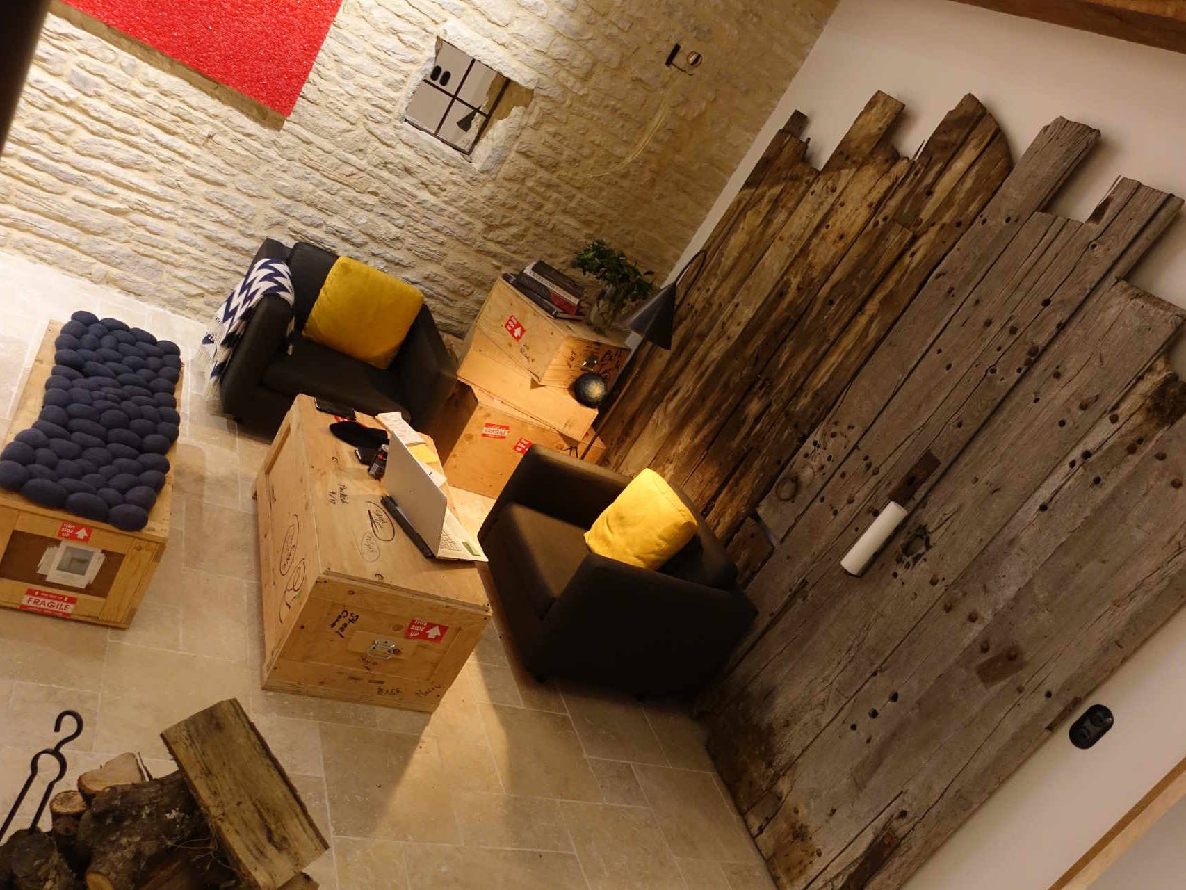 15th century barn conversion seating area with original salvaged arched barn door relief wall.